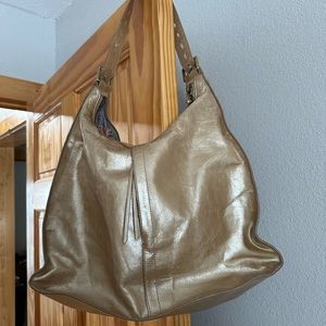 HOBO brand shoulder bag, metallic gold in color